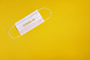 Surgical mask over minimalist orange background