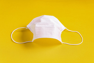 Surgical mask over minimalist orange background