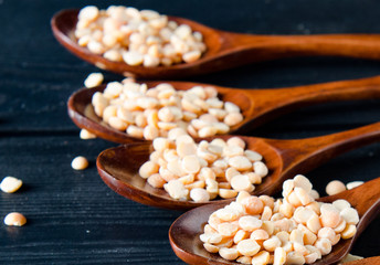 Spoons filled with uncooked lentil for soup