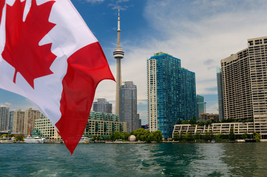Canadian flag on boat leaving Toronto skyline and harbourfront on Lake Ontario