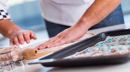 Young man cooking cookies in kitchen