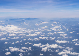 Fototapeta premium Aerial shot of blue sky with clouds and mountain view from plane