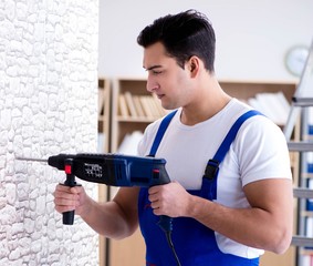 Repairman working with drilling drill perforator