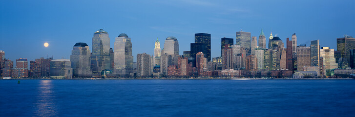 Fototapeta premium Panoramic view of full moon rising over lower Manhattan skyline, NY where World Trade Towers were located