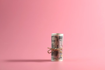Rolls of Japanese yen on pink background, the currency notes from Japan