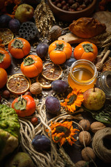 Pumpkins, persimmon, cereals, bread, seeds and nuts on a wooden background, Harvest, Autumn