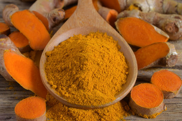 Turmeric powder and fresh turmeric (curcumin) on wooden background,Used for cooking and as herbal medicine.