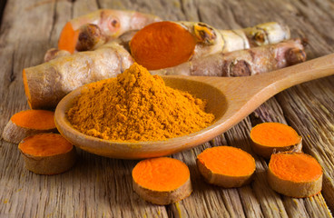 Turmeric powder and fresh turmeric (curcumin) on wooden background,Used for cooking and as herbal medicine.