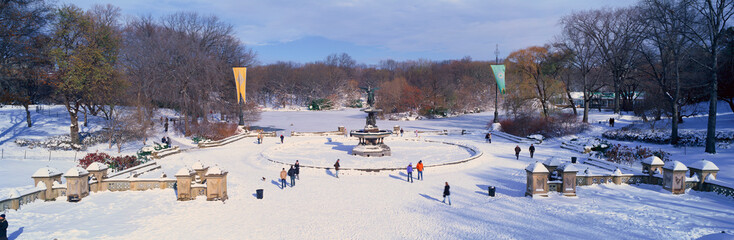 Panoramic view of water fountain covered with fresh winter snow in Central Park, Manhattan, New York City