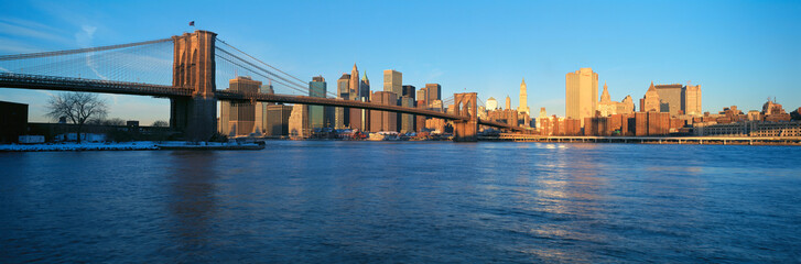 Fototapeta na wymiar Panoramic view of Brooklyn Bridge and East River at sunrise with New York City, where World Trade Towers were located, NY