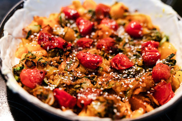 plant-based food recipes, vegan pie with pumpkin zucchini and roasted cherry tomatoes getting prepared