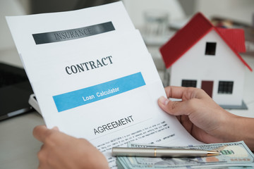 The client is carrying the contract, document, agreement, loan, and insurance to buy the house.