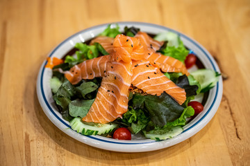 Salmon Salad with cherry tomatoes on Wooden table background