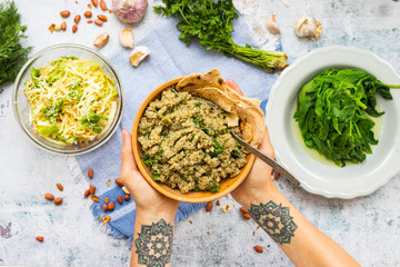Cooked quinoa grain seeds porridge. Woman hands