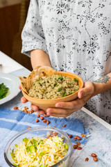 Cooked quinoa grain seeds porridge. Woman hands