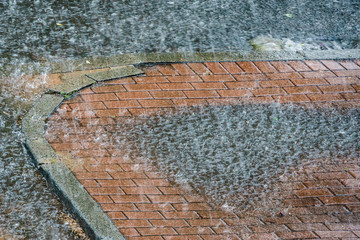 Heavy rain drops falling on city street.