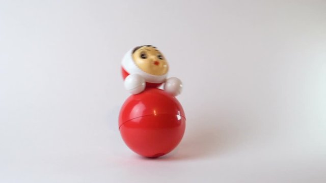 Swinging toy. Roly-poly toy. Nice children's design. Red color. The material is plastic. Made in Russia. White background.