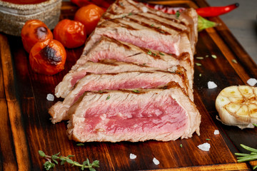 Keto ketogenic diet grilled fried beef steak, striploin on cutting board, side view, close up