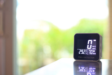 air quality sensor placing on a table indoor. sensor found small amount of air pollution of PM 2.5 the poisonous harmful particulate matter invisible dust from open field fire. man-made disasters.