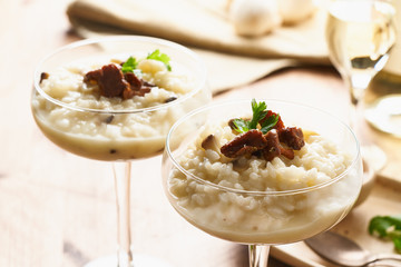 Risotto with mushrooms in wine glass. Unconventional unusual serving. Close up