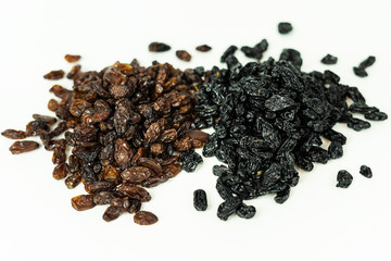 Fototapeta na wymiar Two types of raisins: brown and black on a white isolated background