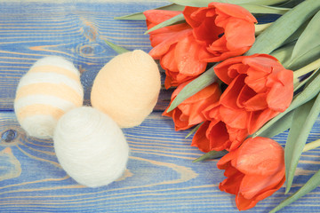 Vintage photo, Tulips and eggs wrapped woolen string on boards as festive Easter decoration