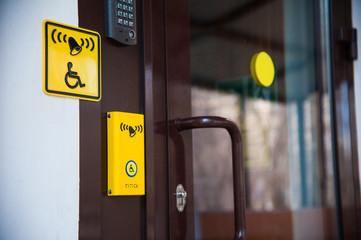 Yellow plate with the image of a disabled person and a call button