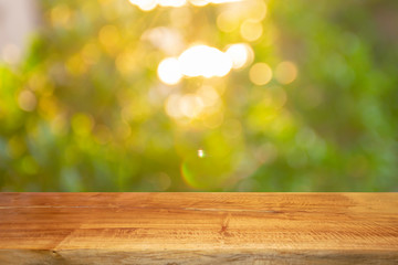 Product display on brown wooden table Against the bokeh background of trees and sunlight