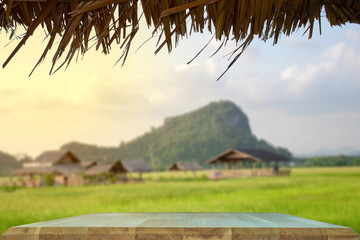 products display on a brown wooden table in the middle of a rice field