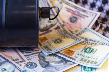 Barrel of oil on a background, american dollars and arabian background. Word on barrel is Oil. Falling trend of barrel price decrease of earning and global economics . Selective focus.