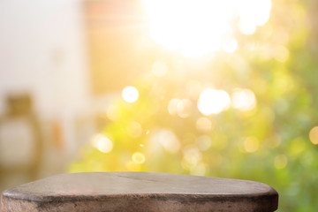 Display the product on a wooden table. The bokeh background from the sun is passing through the leaves