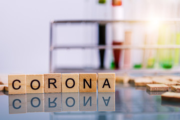 Corona virus wooden text on the black table with test tube in laboratory background