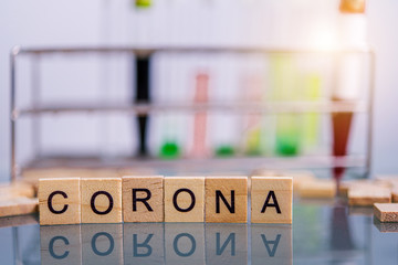 Corona virus wooden text on the black table with test tube in laboratory background