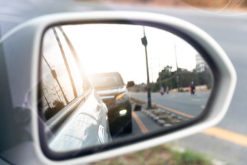 Side view of car mirror traffic of rear-end vehicles on the road.