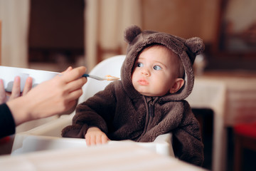 Funny Baby Sitting in Highchair Refusing to Eat  - obrazy, fototapety, plakaty