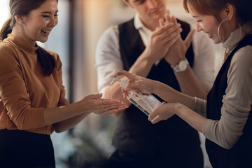 Covid-19 or Corona Virus Situation in Business Concept. Business People Keep Hand Clean with an Alcohol Gel in Office