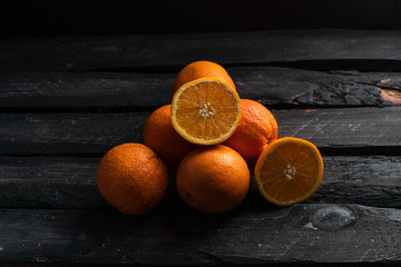 citrus fruit, pile of oranges on a dark wooden backdrop