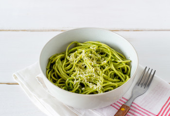 Pasta spaghetti with pesto sauce on a wooden background. National kitchen. Healthy eating. Vegetarian food. Recipe.