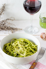 Pasta spaghetti with pesto sauce on a wooden background. National kitchen. Healthy eating. Vegetarian food. Recipe.