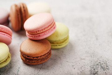 French macaroni cookies of different colors are on the gray table. Still life of confectionery.
