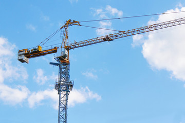 Crane. Construction crane. Building crane on the background of blue sky. Huge crane.