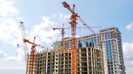 Four tower cranes at the construction site. Skyscraper construction.