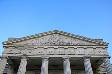 Old Soviet building with columns against the blue sky.