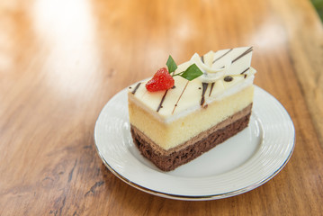 Fresh strawberry cheesecake on wooden table background. Selective focus on the front upper edge of the cake.