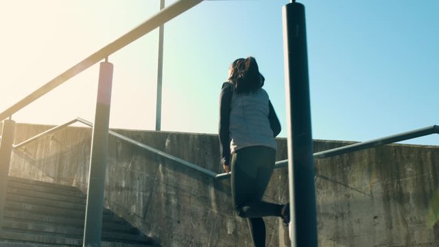 A fit sportswoman jogging upstairs during winter in slow motion