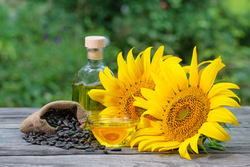 Sunflower oil in bottle and saucer with sunflower flowers