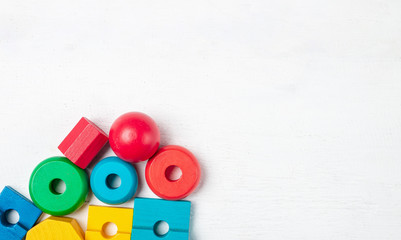 Colorful kids toys on white wooden background. Top view. Flat lay. Copy space for text