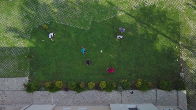 Top view drone shot of some guys playing football in the yard