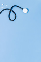 Medical vertical blue background with stethoscope and tablets.