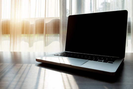 An Open Laptop With Black Screen Monitor On Wooden Table In Office. A Laptop Is A Computer Which Is Easy To Carry Around.